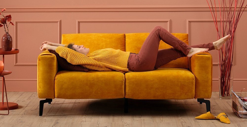 Frau streckt sich auf einem Sensoo Sofa